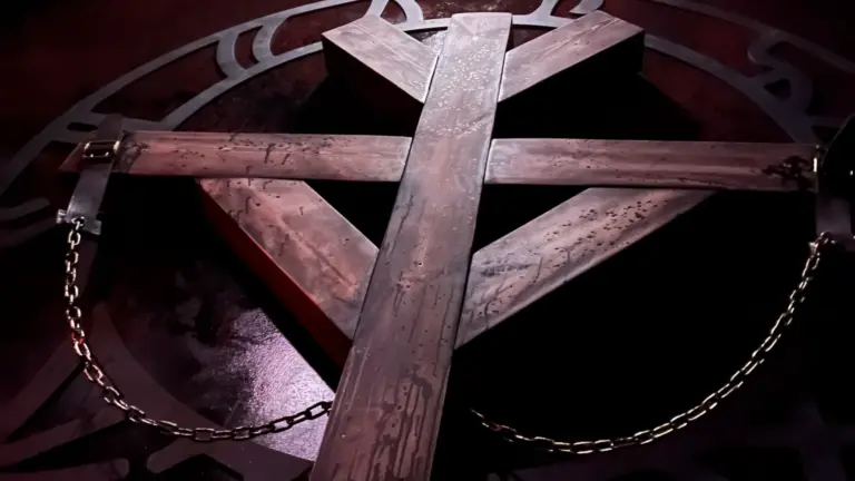 Umgedrehtes Holzkreuz über einem Ritualzeichen, an Ketten befestigt — Escape Room Sanctum in Freiburg